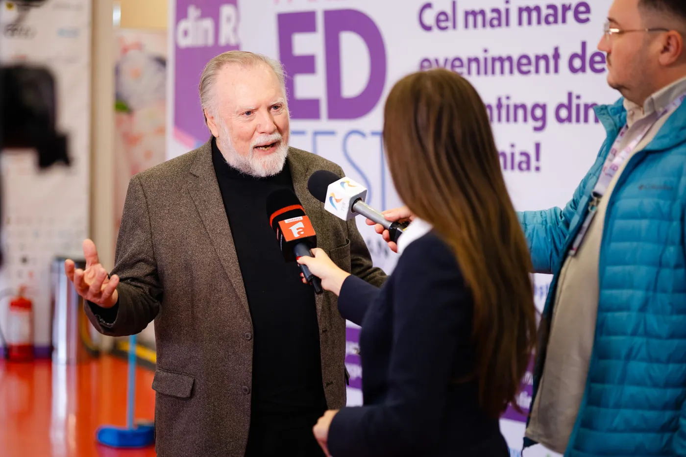 Speaker oferind un interviu presei în fața bannerului ParentED Fest